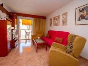 a living room with a red couch and a table at Apartment Colom by Interhome in Malgrat de Mar