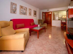 a living room with a red couch and a table at Apartment Colom by Interhome in Malgrat de Mar