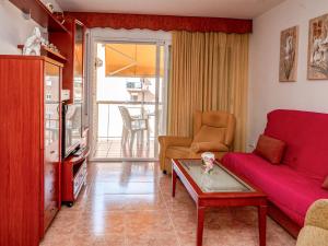 a living room with a red couch and a table at Apartment Colom by Interhome in Malgrat de Mar +31 photos
