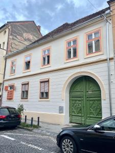 a building with a green door on a street at Apartament Turnul Olarilor in Sibiu