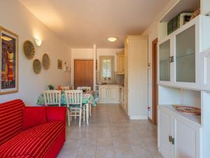 ein Wohnzimmer mit einem roten Sofa und einer Küche in der Unterkunft Apartment Bot by Interhome in Gravedona