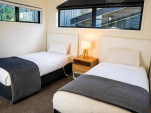 two beds in a room with two windows at Wild Remarks in Queenstown