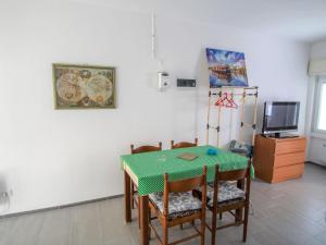 ein Esszimmer mit einem Tisch und Stühlen sowie einem TV in der Unterkunft Studio Borghetto-2 by Interhome in Agra