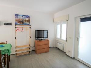 ein Wohnzimmer mit einem TV auf einer Holzkommode in der Unterkunft Studio Borghetto-2 by Interhome in Agra