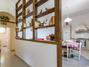 una cocina con estanterías de madera y una mesa en Holiday Home Casa Violella by Interhome, en Chiusi