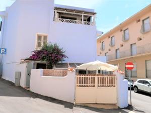 a white building with a gate and an umbrella at Apartment Rosemary by Interhome in Palau