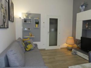 ein Wohnzimmer mit einem grauen Sofa und einem TV in der Unterkunft Apartment Le Due Madonne by Interhome in Bologna