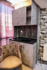 eine Küche mit einer Theke und einem Stuhl in einem Zimmer in der Unterkunft ROYAL SUİT in Bursa