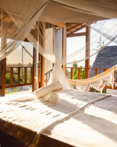 uma cama num quarto com rede de descanso em Chalet du Kite em Praia do Preá