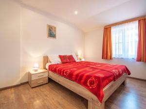 ein Schlafzimmer mit einem großen Bett mit einer roten Decke in der Unterkunft Apartment Fruk-3 by Interhome in Jadranovo
