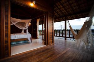 a bedroom with a hammock and a view of the ocean at Chalet du Kite in Prea