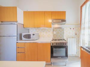 y cocina con fogones y microondas. en Apartment Cinzia by Interhome en Viareggio