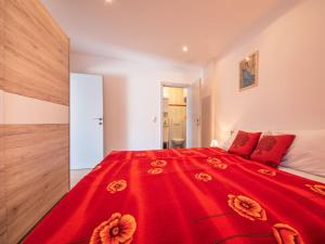 ein Schlafzimmer mit einem roten Bett mit roten Kissen in der Unterkunft Apartment Fruk-3 by Interhome in Jadranovo