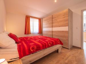 ein Schlafzimmer mit einem Bett mit einer roten Decke in der Unterkunft Apartment Fruk-3 by Interhome in Jadranovo