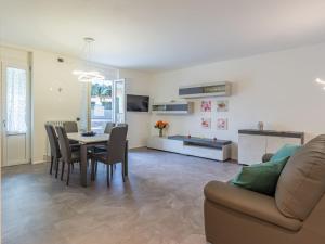 un soggiorno con tavolo, sedie e divano di Apartment Livia by Interhome a Gravedona Altre 29 foto