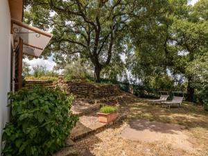 een tuin met 2 stoelen en een stenen muur bij Holiday Home Casa Bianca by Interhome in Scansano