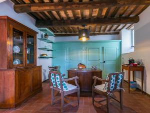 eine Küche mit blauen Wänden, 2 Stühlen und einem Tisch in der Unterkunft Holiday Home La Torre by Interhome in Stigliano