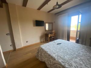 a bedroom with a bed and a table and a window at Hotel Rural Centro de las Arribes in Aldeadávila de la Ribera