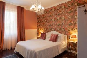 um quarto com uma cama com papel de parede floral em Residenza Ambrogi em Urbino