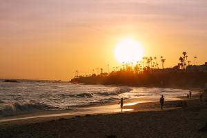 un gruppo di persone sulla spiaggia al tramonto di Sonder Woods Cove a Laguna Beach