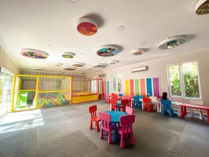 una stanza con tavoli e sedie colorati in un asilo di Catamaran Quality Times a Beldibi