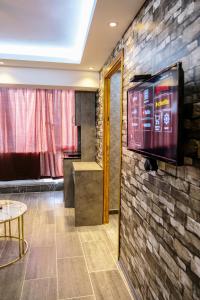 a room with a tv on a brick wall at ROYAL SUİT in Bursa