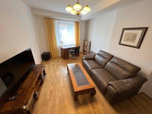 - un salon avec un canapé en cuir et une table basse dans l'établissement I&M Apartments Swiętego Mikołaja Wrocław, à Wrocław