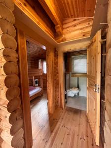 Habitación de madera con cama y ventana en Harrys Blockhütte, en Karres