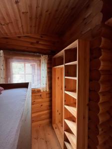 a log cabin with a book shelf in a room at Harrys Blockhütte in Karres