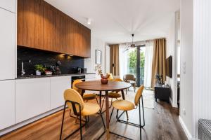 uma cozinha e sala de jantar com mesa e cadeiras em Scala Apartments by HappyStay em Gdansk