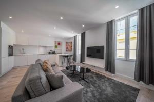 a living room with a couch and a kitchen at Charming apartment for 4 people - Forville - 100m from the Old Port in Cannes