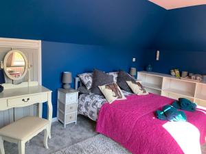 Habitación azul con cama, escritorio y espejo. en Silverspring Farm En suite, en Constantine