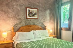 a bedroom with a bed and two lamps and a window at Vista Arinsal Apartments in Arinsal