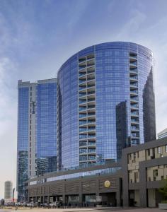 a large building with mirrored windows in a city at Radisson Blu Hotel, Dubai Waterfront in Dubai