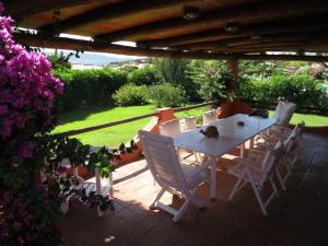 Cala BittaにあるVilla 200 mt from the beach - Baja Sardiniaのパティオの白いテーブルと椅子