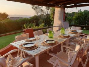 Cala BittaにあるVilla 200 mt from the beach - Baja Sardiniaの白いテーブル(皿、メガネ付)