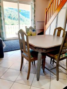 einen Tisch und Stühle in einem Zimmer mit Fenster in der Unterkunft Gite Tropical 