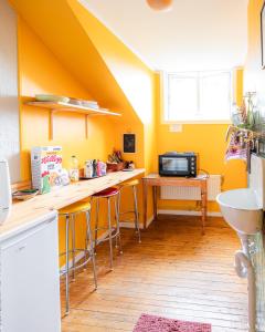a kitchen with yellow walls and counters and a sink at Tiglkåk in Åndalsnes