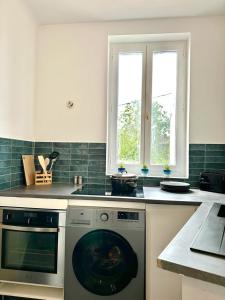 a kitchen with a stove and a dishwasher at Magnifique Appartement proche Stade de France in Saint-Denis