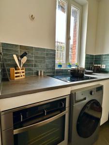 a kitchen with a stove and a washing machine at Magnifique Appartement proche Stade de France in Saint-Denis