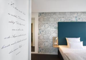 a bedroom with a bed and a blue wall at Grimm's Potsdamer Platz in Berlin