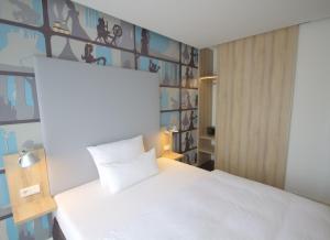 a bedroom with a bed and a wall with pictures on it at Grimm's Potsdamer Platz in Berlin