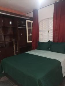 a bedroom with a green bed and a window at Casa para temporada até 9 pessoas, próximo Cabo Frio e São Pedro da Aldeia in São Pedro da Aldeia +31 photos