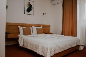 Hotel Serdar في مويكوفاتش: غرفة نوم عليها سرير وفوط