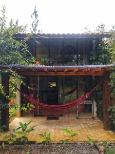 d'une terrasse avec un hamac rouge dans le jardin. dans l'établissement CHALÉS DA VILLA, à Vale do Capão