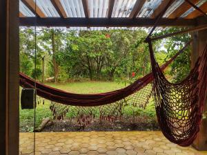 a hammock in a room with a view of a garden at CHALÉS DA VILLA in Vale do Capao