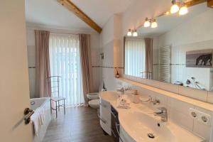 a bathroom with two sinks and a large mirror at Penthouse in Sonthofen in Sonthofen
