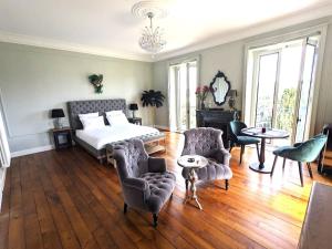 - une chambre avec un lit, un canapé et des chaises dans l'établissement Villa Morton - Domaine du Grand Tourmalet Pic du Midi, à Bagnères-de-Bigorre
