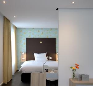 a bedroom with a large white bed and a desk at Grimm's Potsdamer Platz in Berlin