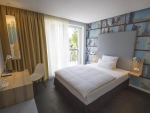 a bedroom with a white bed and a window at Grimm's Potsdamer Platz in Berlin